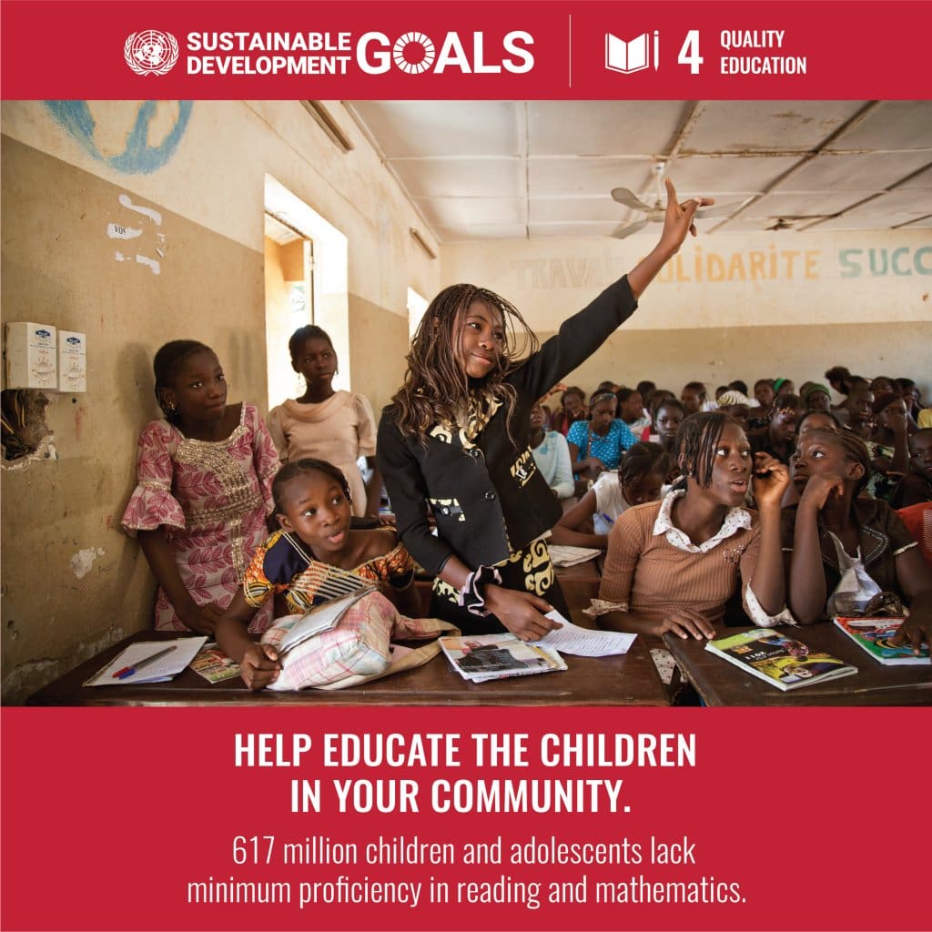 A woman sitting in front of a classroom with other children.