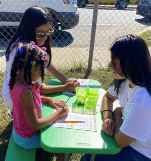 Three girls sitting at a table with papers