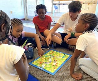 A group of kids playing a board game.