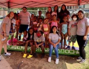 A group of children posing for a picture under a tent.