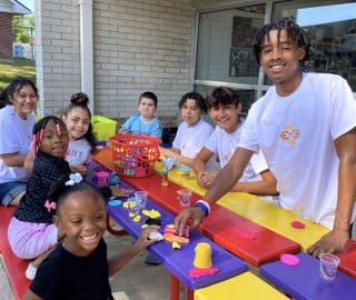 A group of children sitting at a table with food.