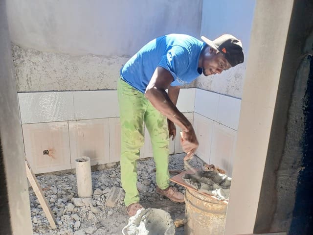 Man tiling wall with cement mortar.