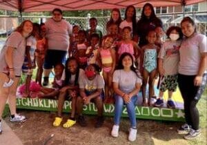 A group of children posing for a picture under a tent.